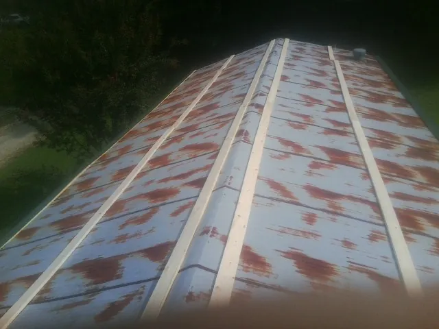 Rusted metal roof panels with new wood purlins before replacement — Storm Damage Roof Repair in Kingwood by Roofing Brothers