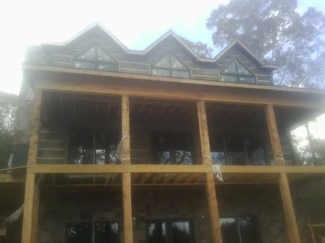 Dormers and porch framing on a large log home under construction — Roof Coating work by our crew in Kingwood