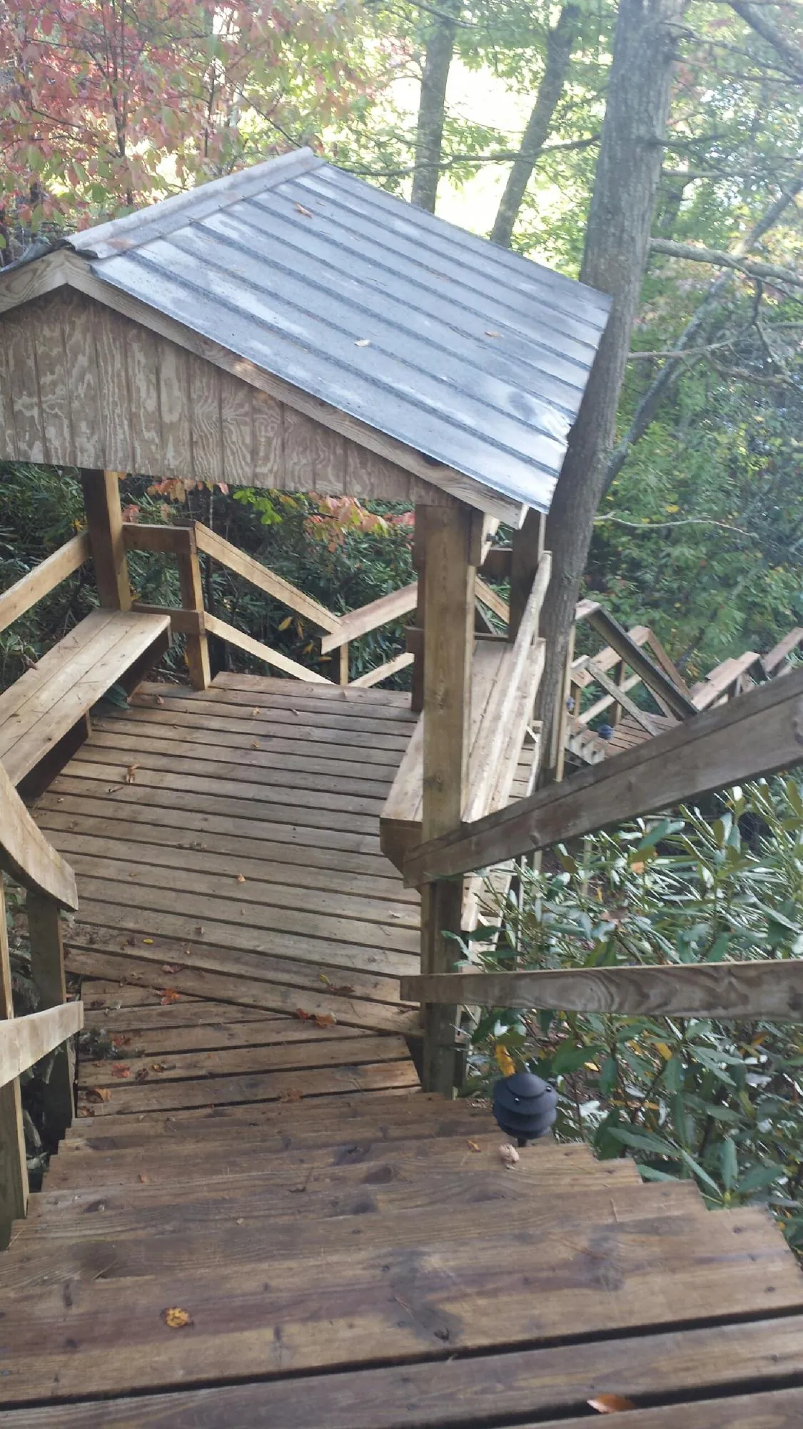 Metal roofed shelter over wooden steps on a wooded walkway — Skylight Repair & Installation work by our crew in Kingwood