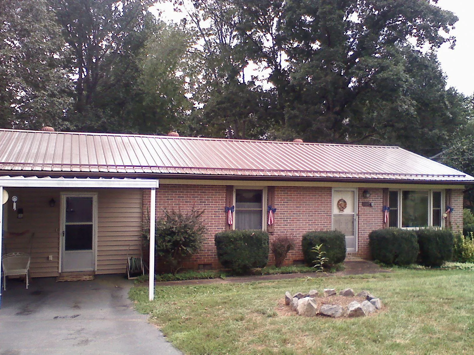 Bronze metal roof and carport on a brick ranch home — Roof Repair work by our crew in Kingwood