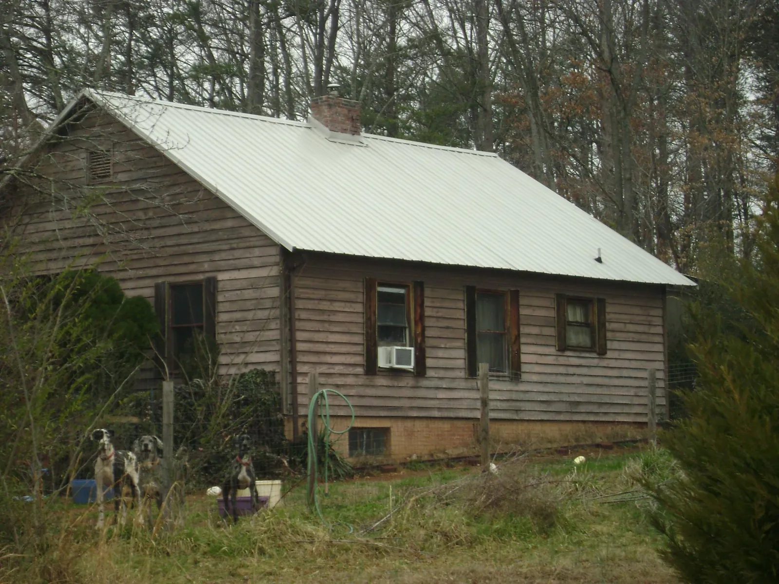 White metal roof on an old wood sided farmhouse, from a Metal Roof Installation job in Kingwood